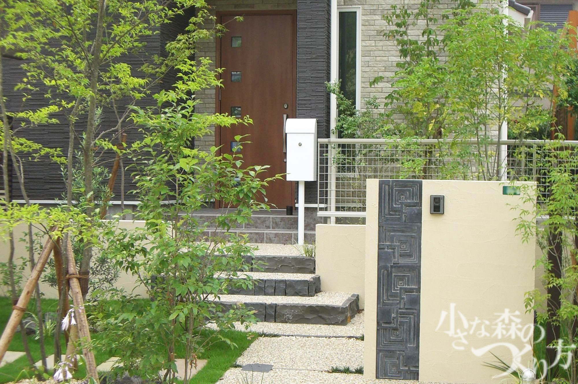 <p>デザインタイルを使った塗り壁の門柱、アプローチの洗出し、化粧砂利も落ち着いた色合いに。</p>