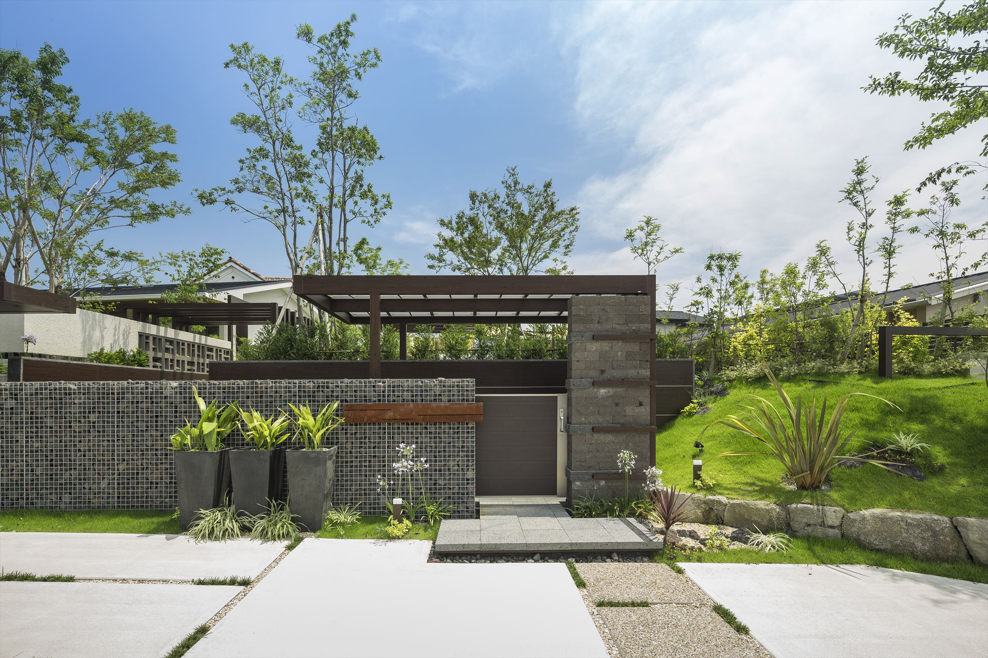 <p>正面から見たファサードです。</p>
<p>広い間口全面をクローズした外構ですが、</p>
<p>素材・色の異なる２タイプの壁を配置し、右側は植栽帯で構成されているので、</p>
<p>圧迫感がなく、仕上がっています。</p>