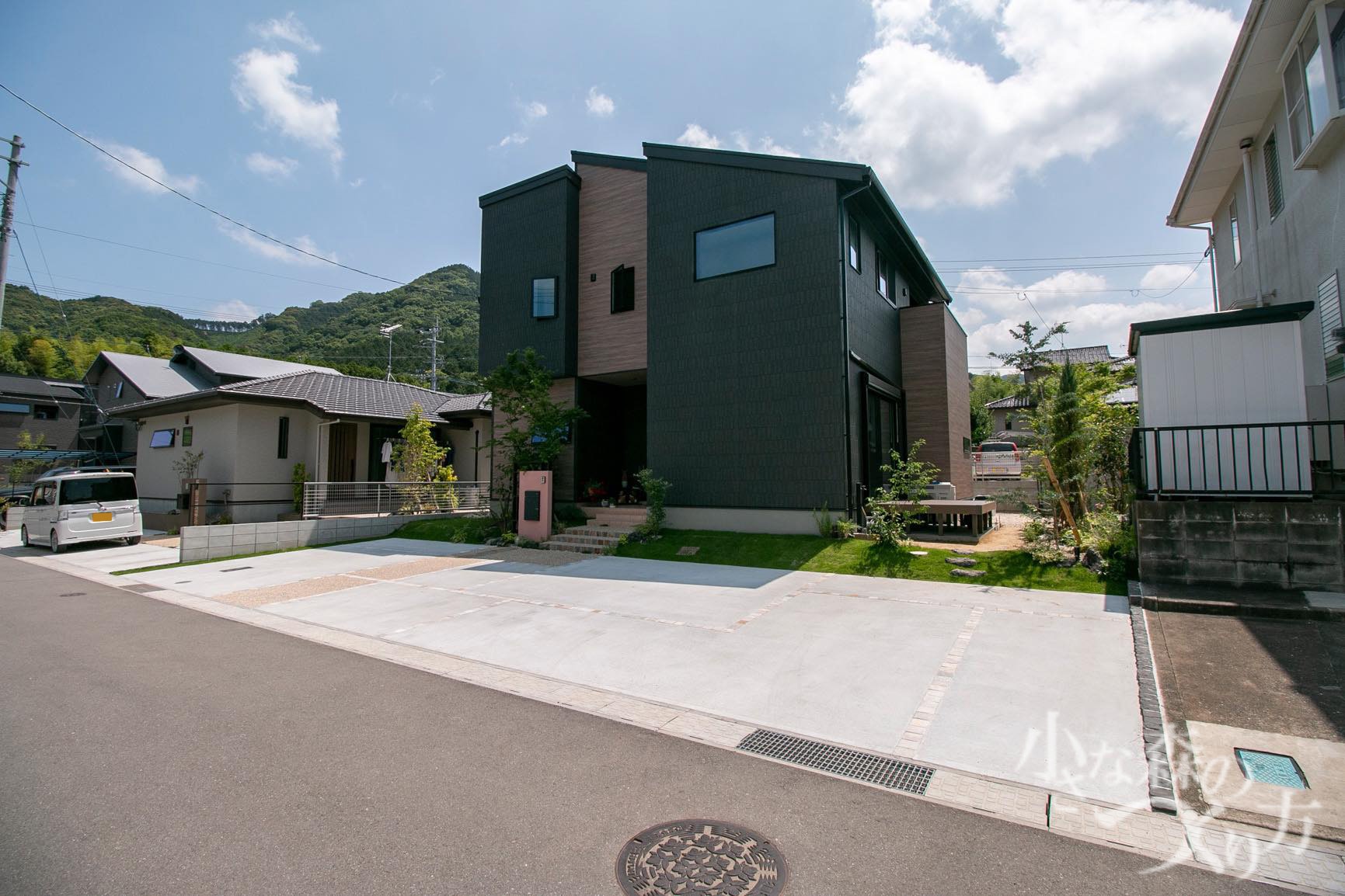 <p>階段の自然石と洗い出しが柔らかい雰囲気を作ります。</p>
<p>法面は芝と樹木で緑豊かに。</p>