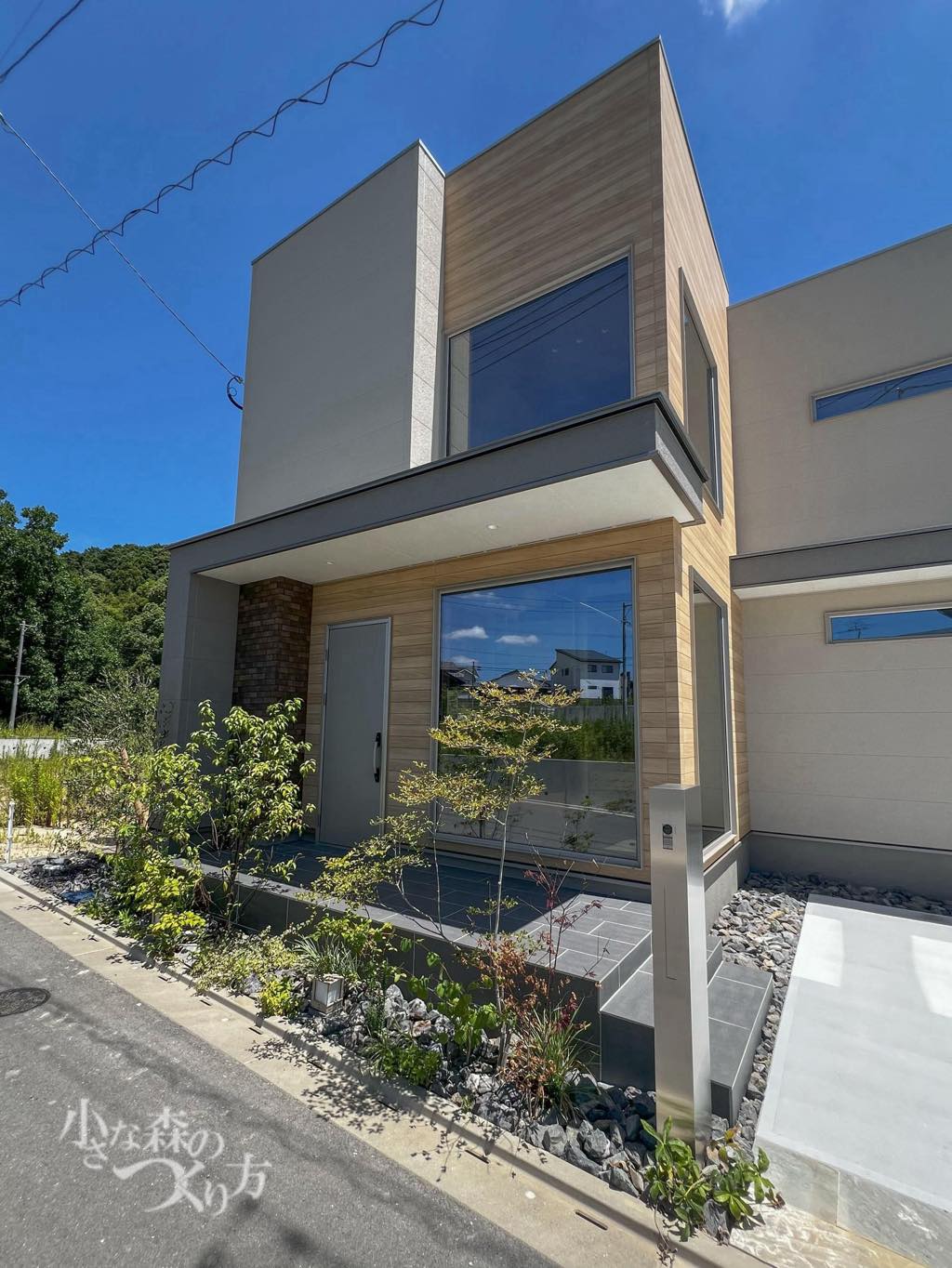 <p>玄関横にはシンプルな門柱を設置。直線的なデザインの中にも、複数の低木や下草に栗石を組み合わせることで柔らかな印象に。</p>